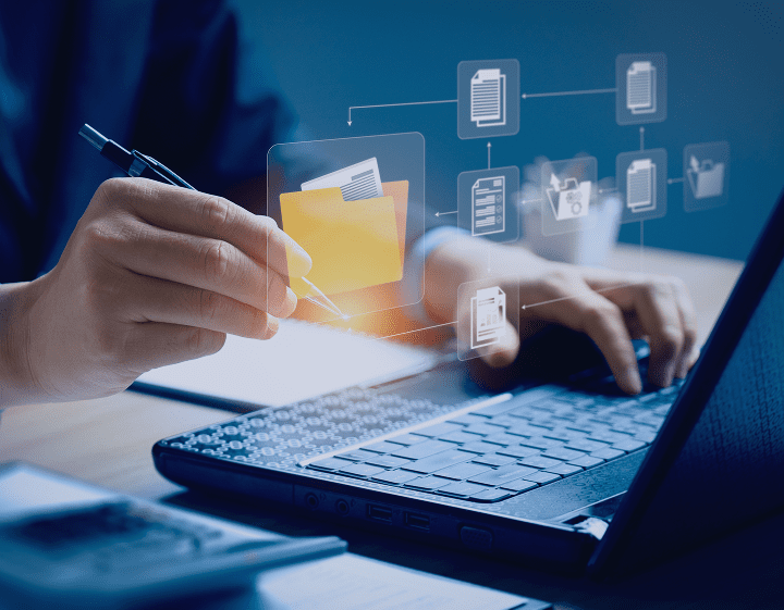 Hands using a laptop with digital file icons.